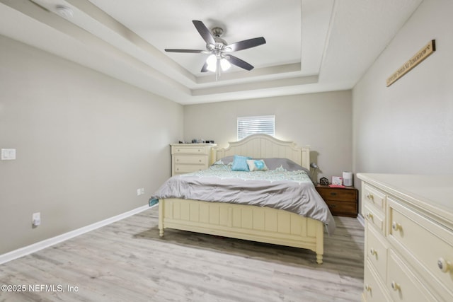 3228 Deer Creek Dr, Middleburg, FL 32068 - bedroom with a raised ceiling, light wood-type flooring, baseboards, and a ceiling fan