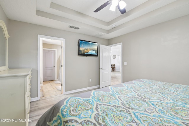 3228 Deer Creek Dr, Middleburg, FL 32068 - bedroom featuring a raised ceiling, baseboards, light wood-style flooring, and a ceiling fan