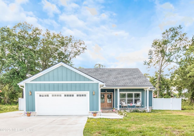 4282 Wolfe Dr, Macclenny, FL 32063 - view of front facade with an attached garage, concrete driveway, a shingled roof, french doors, and board and batten siding