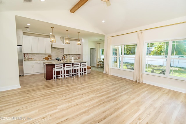 4282 Wolfe Dr, Macclenny, FL 32063 - kitchen with stainless steel fridge, a breakfast bar, backsplash, light wood-type flooring, and recessed lighting