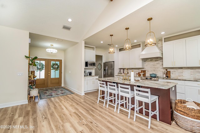4282 Wolfe Dr, Macclenny, FL 32063 - kitchen with appliances with stainless steel finishes, backsplash, a kitchen bar, light wood-style flooring, and light stone counters