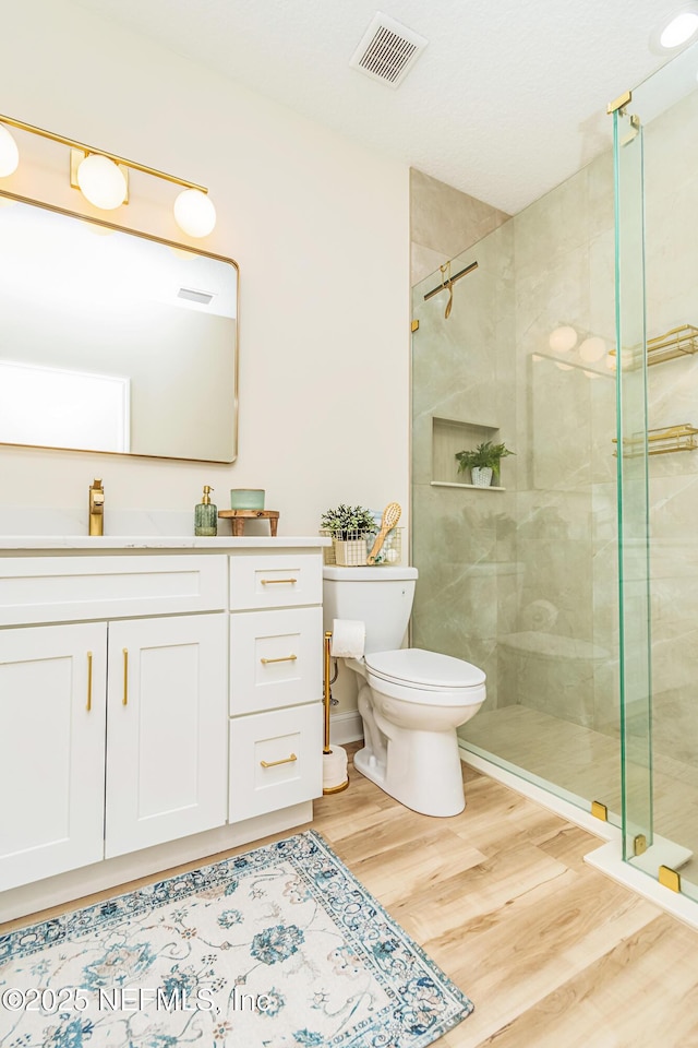 4282 Wolfe Dr, Macclenny, FL 32063 - bathroom featuring wood finished floors, a shower stall, toilet, and vanity