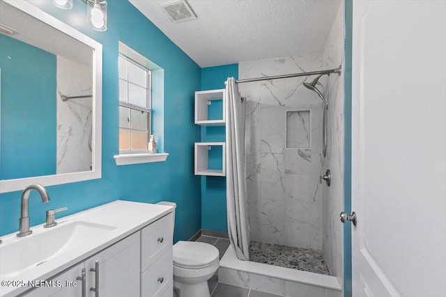 full bathroom featuring toilet, a marble finish shower, a textured ceiling, and vanity