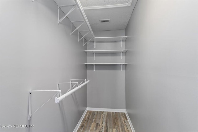 spacious closet with dark wood-style floors