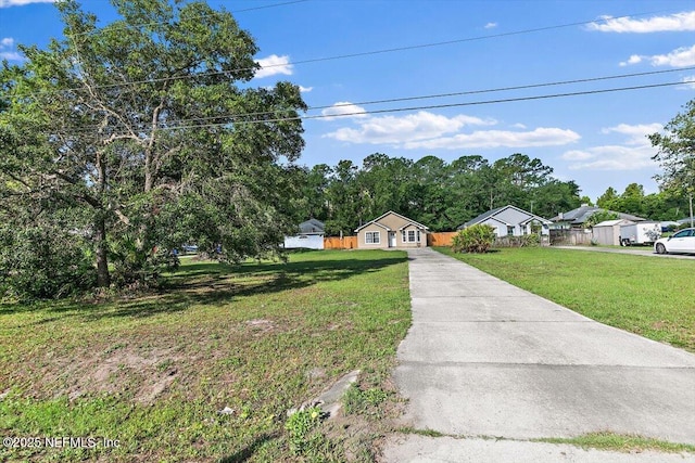 ranch-style home featuring concrete driveway and a front lawn