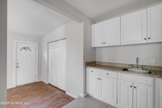 944 Bunker Hill Blvd, Jacksonville, FL 32208 - kitchen featuring a sink, white cabinetry, light wood-type flooring, and baseboards