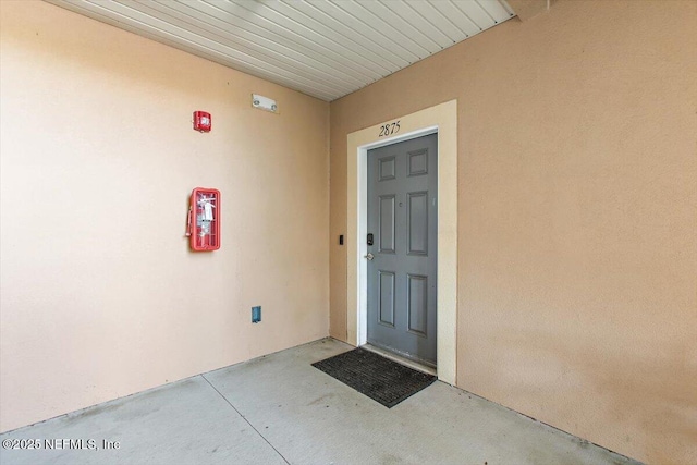 doorway to property featuring stucco siding