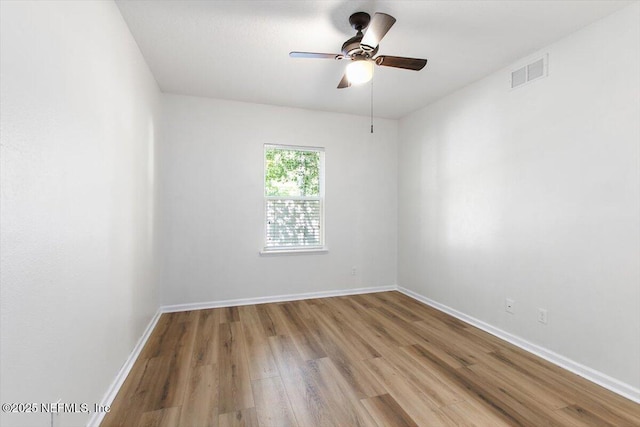 empty room featuring wood finished floors, ceiling fan, and baseboards