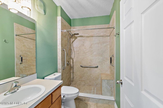 full bathroom featuring a stall shower, a textured ceiling, vanity, toilet, and tile patterned flooring
