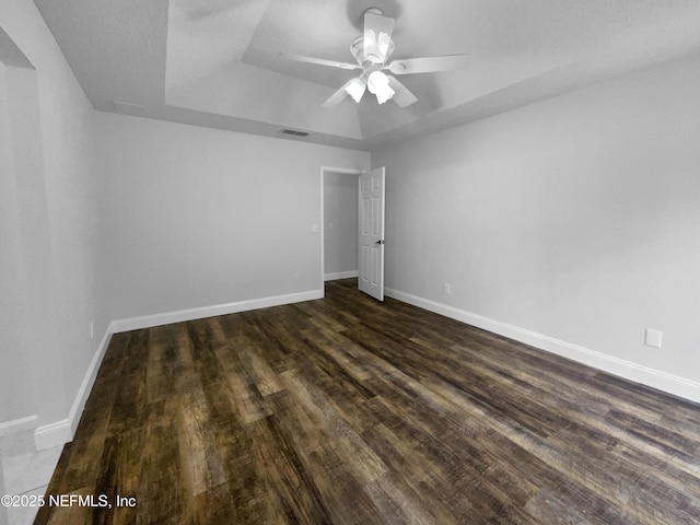 3055 Nautilus Rd, Middleburg, FL 32068 - unfurnished bedroom with a tray ceiling, dark wood-type flooring, and baseboards