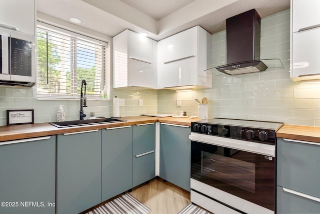 5375 Ortega Farms Blvd Unit 408, Jacksonville, FL 32210 - kitchen featuring wall chimney exhaust hood, white electric stove, butcher block countertops, a sink, and decorative backsplash
