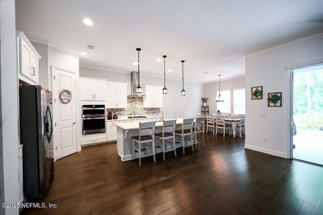 152 Cloverbrook Rd, Saint Johns, FL 32259 - kitchen with refrigerator with ice dispenser, stainless steel double oven, ornamental molding, plenty of natural light, and a kitchen breakfast bar
