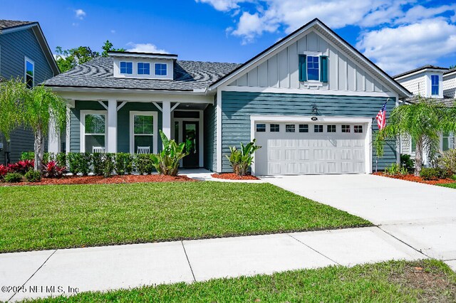 152 Cloverbrook Rd, Saint Johns, FL 32259 - view of front of house featuring an attached garage, board and batten siding, concrete driveway, a front lawn, and a shingled roof