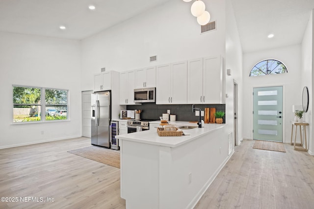 550 Robles Ln, Ponte Vedra Beach, FL 32082 - kitchen with stainless steel appliances, a towering ceiling, a sink, light wood-style flooring, and light countertops