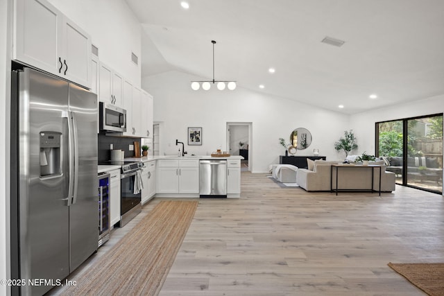 550 Robles Ln, Ponte Vedra Beach, FL 32082 - kitchen featuring stainless steel appliances, open floor plan, lofted ceiling, light wood-type flooring, and a peninsula