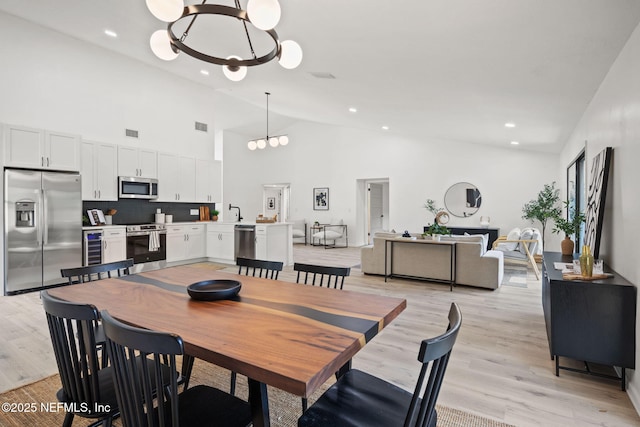 550 Robles Ln, Ponte Vedra Beach, FL 32082 - dining area with a chandelier, light wood-style floors, high vaulted ceiling, recessed lighting, and wine cooler