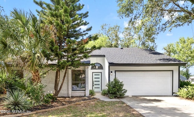 550 Robles Ln, Ponte Vedra Beach, FL 32082 - view of front of house featuring roof with shingles, concrete driveway, a garage, and brick siding