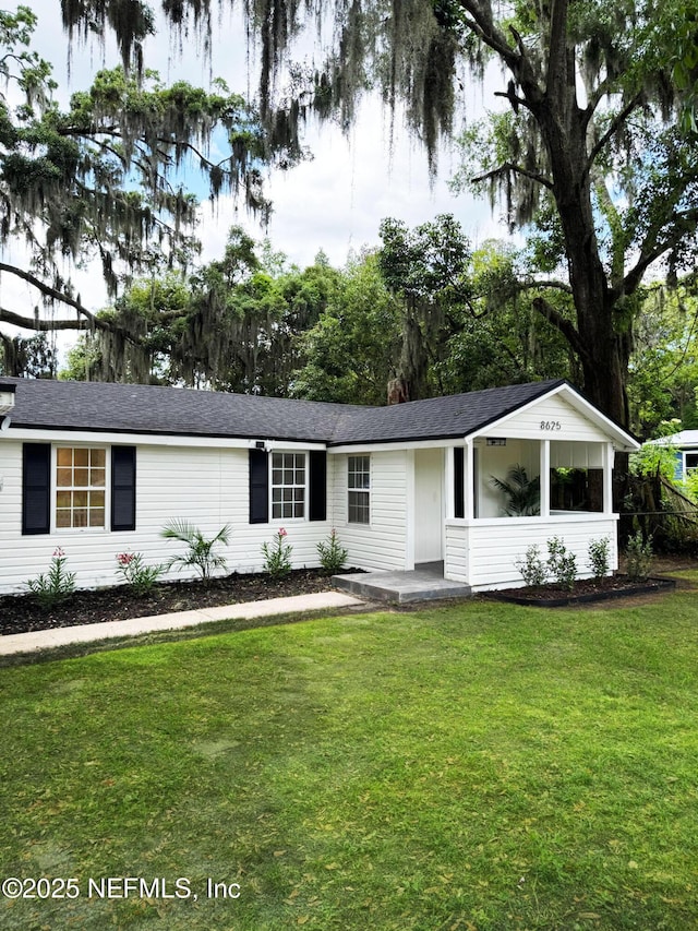 ranch-style house featuring a front lawn and a shingled roof