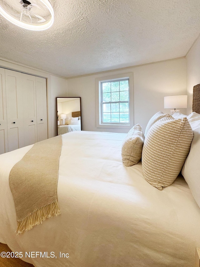 bedroom featuring a textured ceiling and a closet