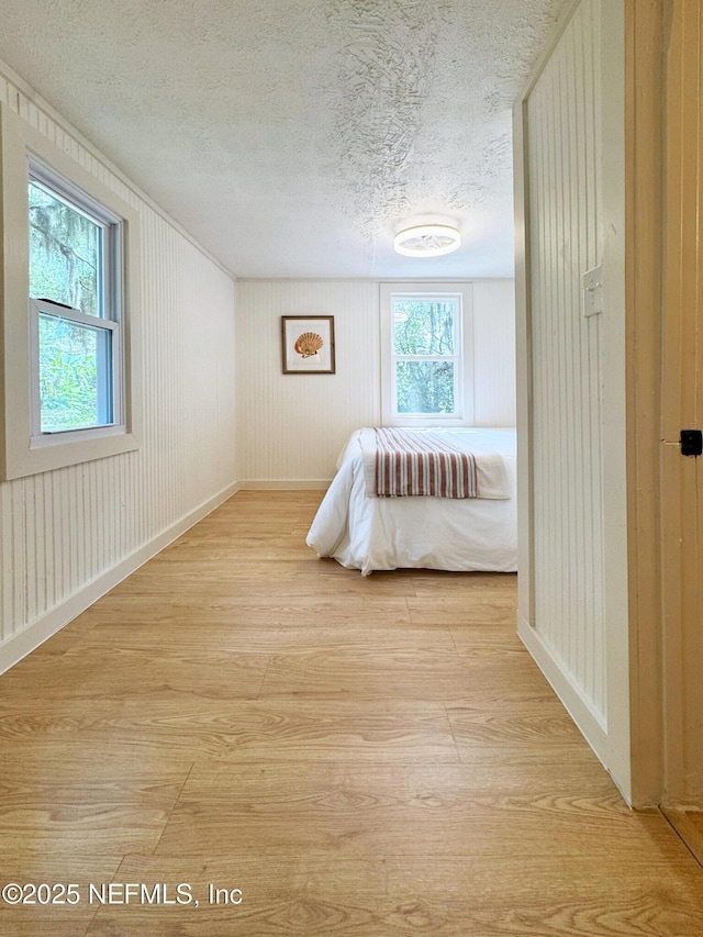 bedroom featuring light wood finished floors and a textured ceiling