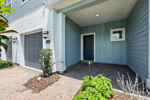 doorway to property with board and batten siding and an attached garage