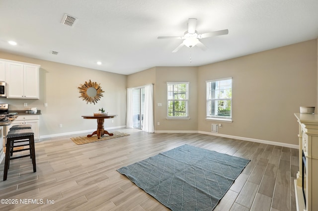 living area featuring light wood-style floors, ceiling fan, baseboards, and recessed lighting