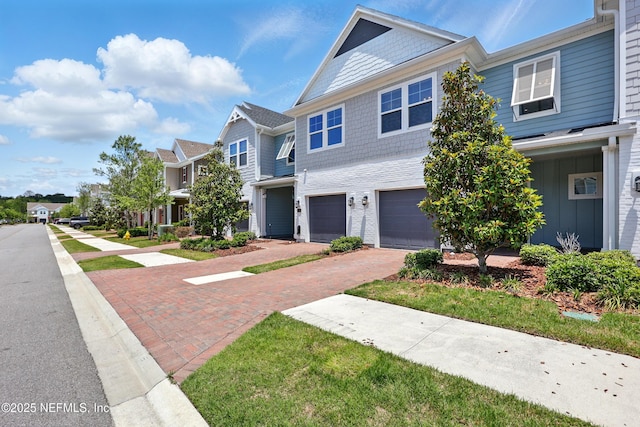 townhome / multi-family property featuring driveway, an attached garage, and a residential view