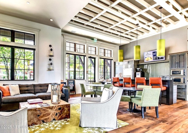 living room featuring light wood-type flooring, a towering ceiling, beam ceiling, coffered ceiling, and recessed lighting