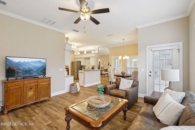 641 Thornwood Ln, Orange Park, FL 32073 - living room with a ceiling fan, ornamental molding, light wood-style floors, a chandelier, and baseboards