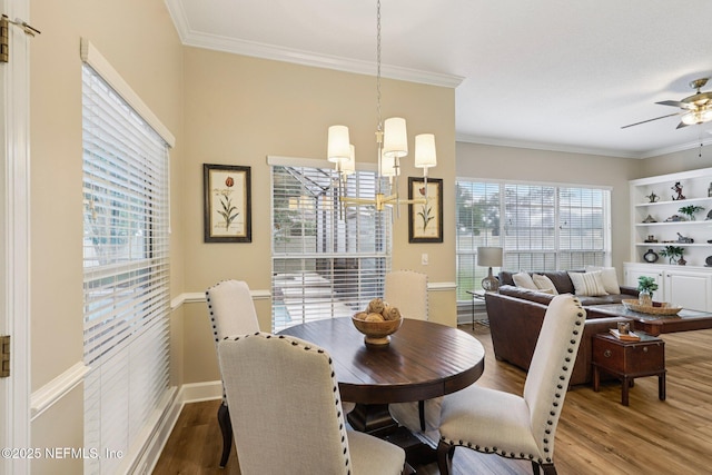641 Thornwood Ln, Orange Park, FL 32073 - dining area with a chandelier, wood finished floors, a ceiling fan, crown molding, and baseboards