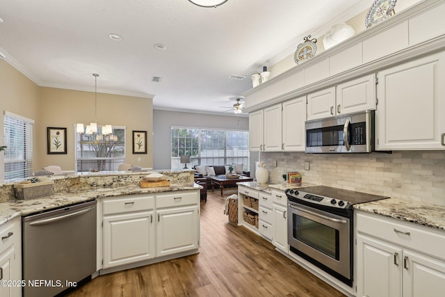 641 Thornwood Ln, Orange Park, FL 32073 - kitchen featuring appliances with stainless steel finishes, a chandelier, tasteful backsplash, white cabinets, and wood finished floors