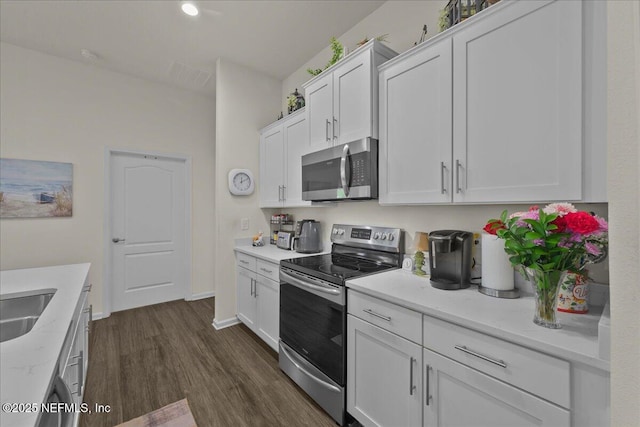 4101 Spring Creek Ln, Middleburg, FL 32068 - kitchen featuring appliances with stainless steel finishes, dark wood-style floors, white cabinets, light stone countertops, and baseboards