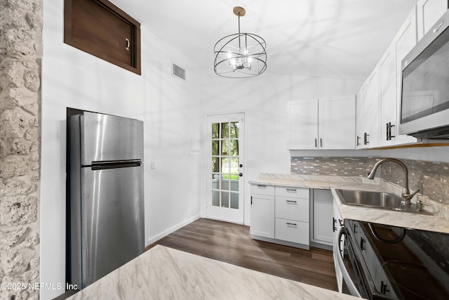 kitchen featuring stainless steel appliances, a sink, decorative backsplash, dark wood finished floors, and white cabinetry