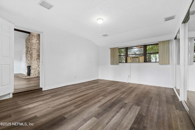 spare room featuring wood finished floors, a fireplace, and baseboards