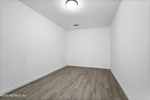 empty room featuring wood finished floors and baseboards