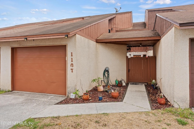 1167 Romaine Cir E, Jacksonville, FL 32225 - view of front of house with roof with shingles, an attached garage, stucco siding, and a gate