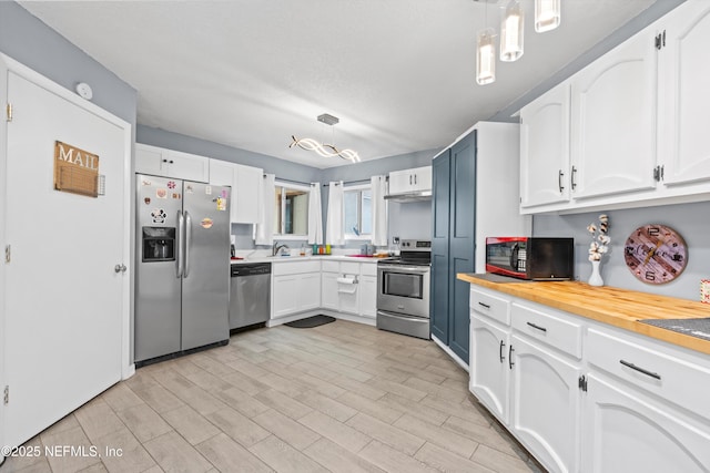 1167 Romaine Cir E, Jacksonville, FL 32225 - kitchen featuring appliances with stainless steel finishes, white cabinetry, and hanging light fixtures