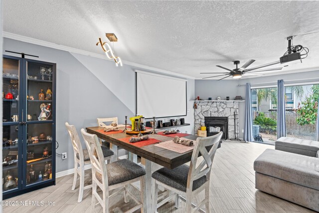 1167 Romaine Cir E, Jacksonville, FL 32225 - dining area featuring a textured ceiling, a ceiling fan, wood finished floors, crown molding, and a fireplace