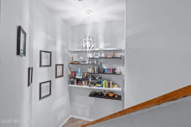 1167 Romaine Cir E, Jacksonville, FL 32225 - corridor with a chandelier, wood finished floors, and baseboards