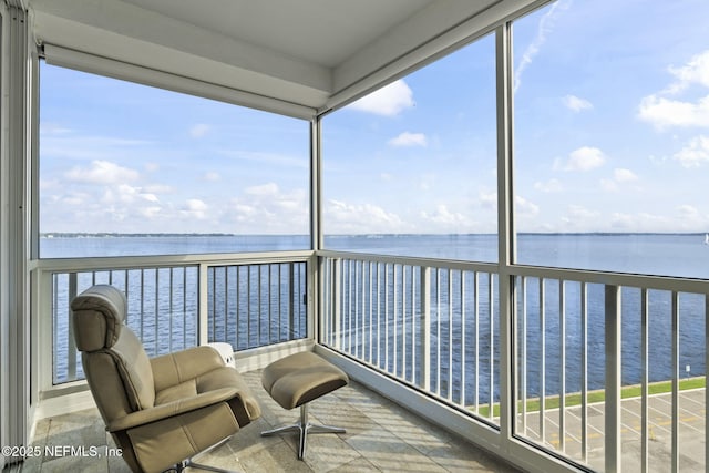 sunroom featuring a water view, healthy amount of natural light, and floor to ceiling windows