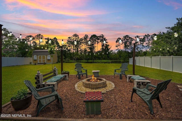 5950 Orchard Pond Dr, Fleming Island, FL 32003 - yard at dusk featuring a fire pit, a storage unit, and an outbuilding