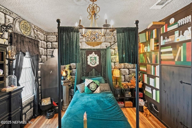 5950 Orchard Pond Dr, Fleming Island, FL 32003 - bedroom featuring wood finished floors, a textured ceiling, and a chandelier