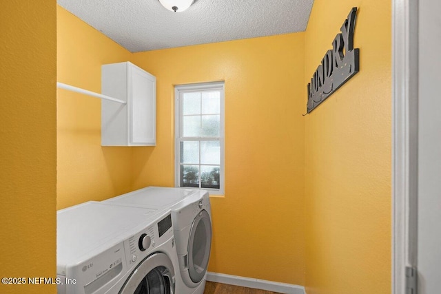 5950 Orchard Pond Dr, Fleming Island, FL 32003 - laundry area featuring washing machine and dryer, a textured ceiling, cabinet space, and baseboards
