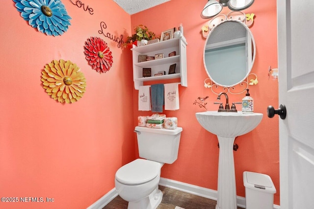 5950 Orchard Pond Dr, Fleming Island, FL 32003 - bathroom with toilet, baseboards, and a textured ceiling