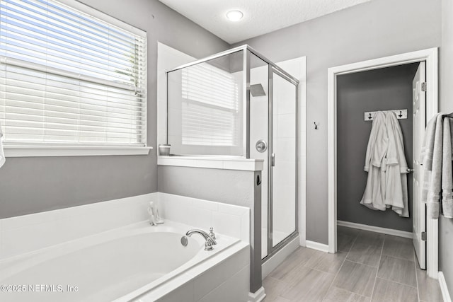 475 Pine Eagle Dr, Fleming Island, FL 32003 - bathroom with a stall shower, a garden tub, plenty of natural light, baseboards, and a textured ceiling