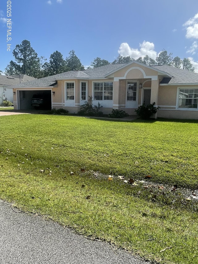 ranch-style house with stucco siding, an attached garage, a front yard, and concrete driveway