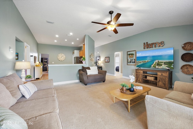 living room featuring ceiling fan, light carpet, lofted ceiling, and baseboards