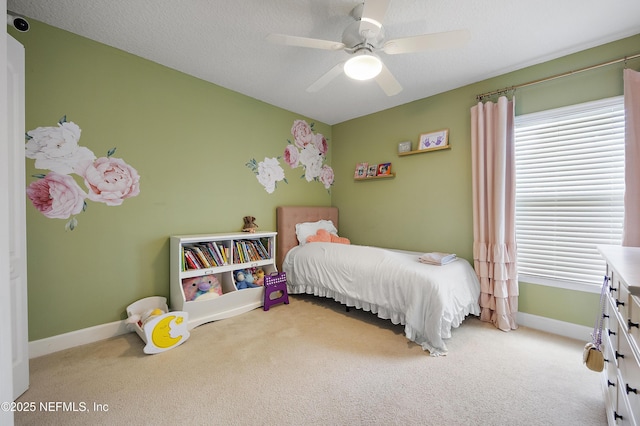 carpeted bedroom featuring baseboards, multiple windows, and ceiling fan