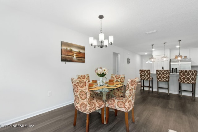 dining area with dark wood-style floors, a chandelier, and baseboards