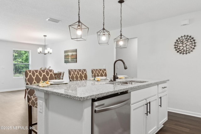 kitchen with dishwasher, a sink, baseboards, and white cabinets